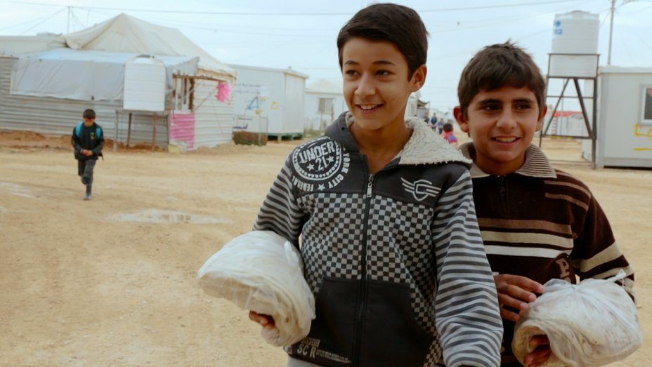 Two smiling boys holding bread