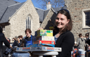 A woman carrying board games outside the church.