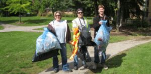 People posing with full garbage bags.