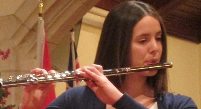 An orchestra member playing the flute.