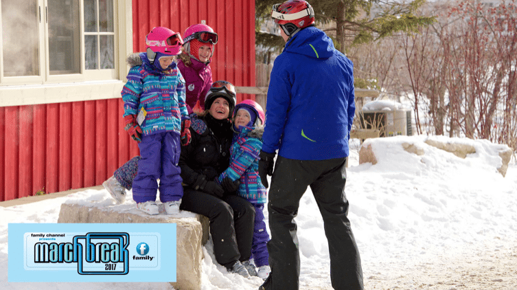 A family wearing ski gear laughing