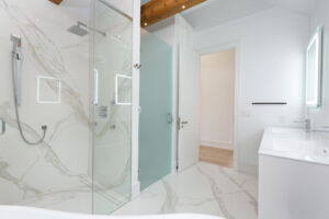 Floating double vanity with illuminated mirrors and contemporary wood cabinetry in the primary ensuite at 28 Martin Grove Road