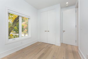 Additional upper-level bedroom at 28 Martin Grove Road featuring hardwood flooring, custom eight-foot doors and organized closet storage