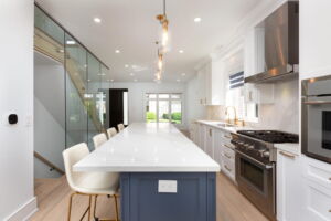 Oversized kitchen island with quartz countertop, breakfast seating and pendant lighting at 28 Martin Grove Road Home for Sale in Etobicoke