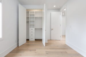 Bright second-floor bedroom at 28 Martin Grove Road featuring wide-plank engineered hardwood floors and a custom-built closet