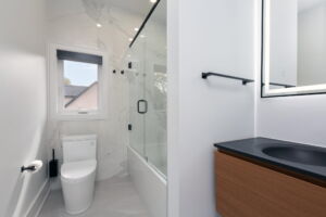 Beautifully renovated second-floor family bathroom at 28 Martin Grove Road featuring marble-look tile and a floating wood vanity